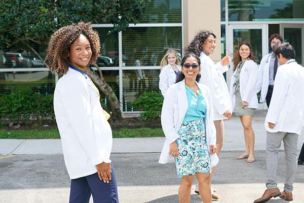 FAU medical students in front of the Schmidt College of Medicine building